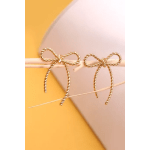 Two gold bow hair clips on a pastel background