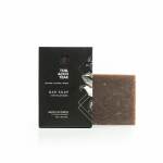 Bar soap with black packaging and a brown soap block