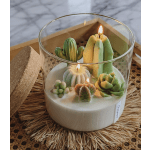Candle in a glass holder decorated with succulent shapes