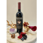 Wine bottle with berries, chocolate pieces, and a purple crystal on a round table
