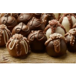 Chocolate-covered pumpkin-shaped treats with decorative drizzles