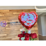 Red heart balloon above a bouquet of red roses
