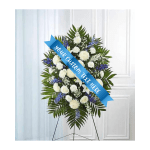 Standing funeral spray of white and blue flowers on an easel