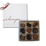 Box of assorted chocolates beside a white card with "i love you" text