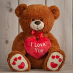 Brown teddy bear holding red heart pillow with 'I Love You' text and red hearts on its paws