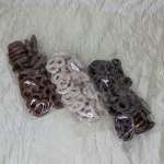 Three bags of ring-shaped dried snacks on a wrinkled white surface