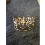 Gold-toned decorative crown with clear rhinestones on dark fabric