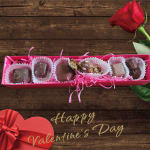 Box of assorted chocolates with a red rose and Valentine gift box