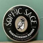 Round tin of hand balm labeled "SOPHIC SAGE"