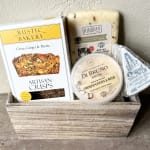 Gift basket with crackers and assorted cheeses in a wooden crate