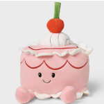 Pink plush cake-shaped toy with a cherry on top