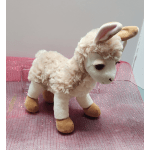 Plush lamb toy standing on pink mesh fabric