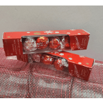 Two red Lindor chocolate truffle boxes on a pink mesh surface