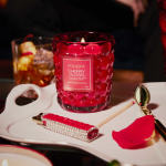 Red glass candle on a tray with a match and lighter