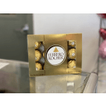 Ferrero Rocher chocolates in a gold box on a glass table