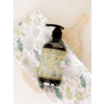 Bottle of hand wash on a patterned cloth with a wooden brush