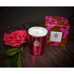 Pink rose beside a metallic candle and patterned gift box