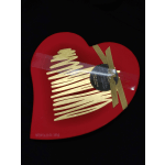 Heart-shaped red chocolate box with a gold ribbon and label