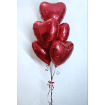 Cluster of red heart-shaped balloons tied with ribbon