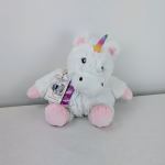 White plush unicorn toy with pink feet and a rainbow horn