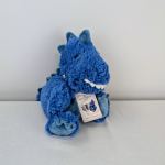 Blue plush dinosaur toy with a product tag