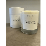 Two white candles labeled Peace on a wooden surface