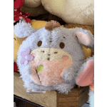 Fluffy blue plush animal with a pink face and flower patch