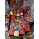 Assorted Lindor chocolate truffle boxes arranged in a basket with tissue paper