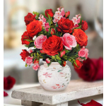 Bouquet of red and pink roses in a white painted vase