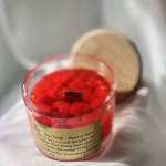Red rose petal candle in a clear glass jar with a wooden lid