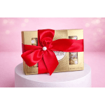 Gold chocolate gift box tied with a red satin ribbon