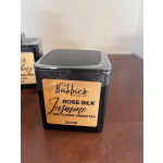 Square black tin of Rose Silk Jasmine floral green tea with gold label on a wooden surface