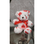 Small white teddy bear with red accents and a red ribbon