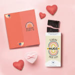 Greeting card and chocolate bar with heart decorations on a pink background