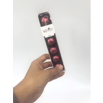Hand holding a box of dark chocolates wrapped in pink foil