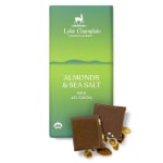 Milk chocolate bar with almonds and sea salt in green wrapper, with two broken squares and nuts in front