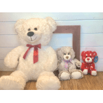 Three teddy bears with ribbons, including a large white bear and two smaller bears