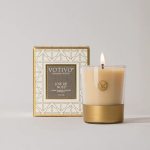 Lit candle in a glass holder beside a decorative box