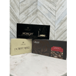 Three boxes of assorted chocolates stacked on a tabletop