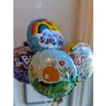 Cluster of colorful foil balloons with cheerful messages and cartoon designs