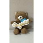 Brown teddy bear holding a "Congrats!" sign and gift card