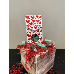 Heart-patterned gift box with wrapped chocolates on a wooden crate