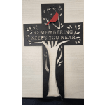 Black cross memorial sign with a red bird and the words "Remembering Keeps You Near"