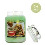 Green jar candle labeled Pistachio & Honey with a lid beside it