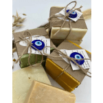 Set of assorted handmade soap bars wrapped in kraft paper with twine and blue evil eye charms.