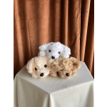 Three plush teddy bear heads stacked on a draped table