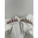 Two jeweled tiaras resting on white fabric
