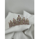 Pink jeweled tiara resting on white fabric