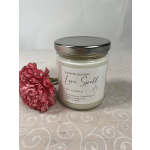 Soy candle in a glass jar beside a pink carnation