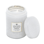 White scented candle in a glass jar with a lid beside it